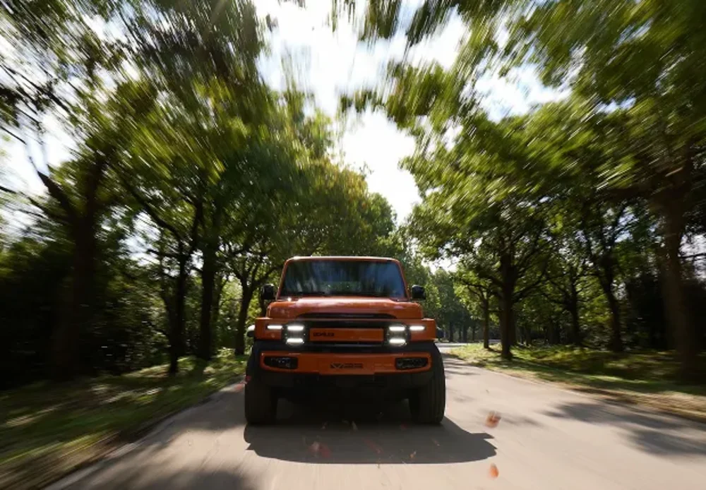 iCAUR V23 driving on a tree-lined road